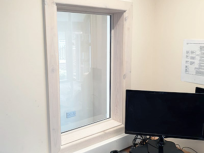 Installation of wooden window to improve light and vision within a school reception area